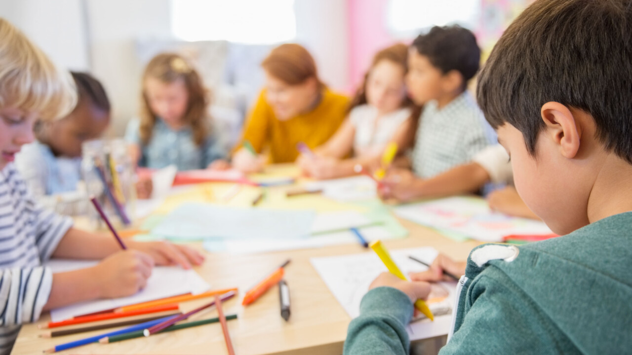 children coloring at a table.