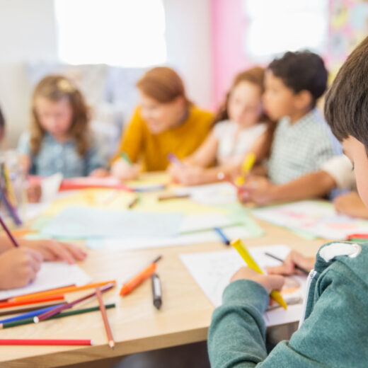 children coloring at a table.