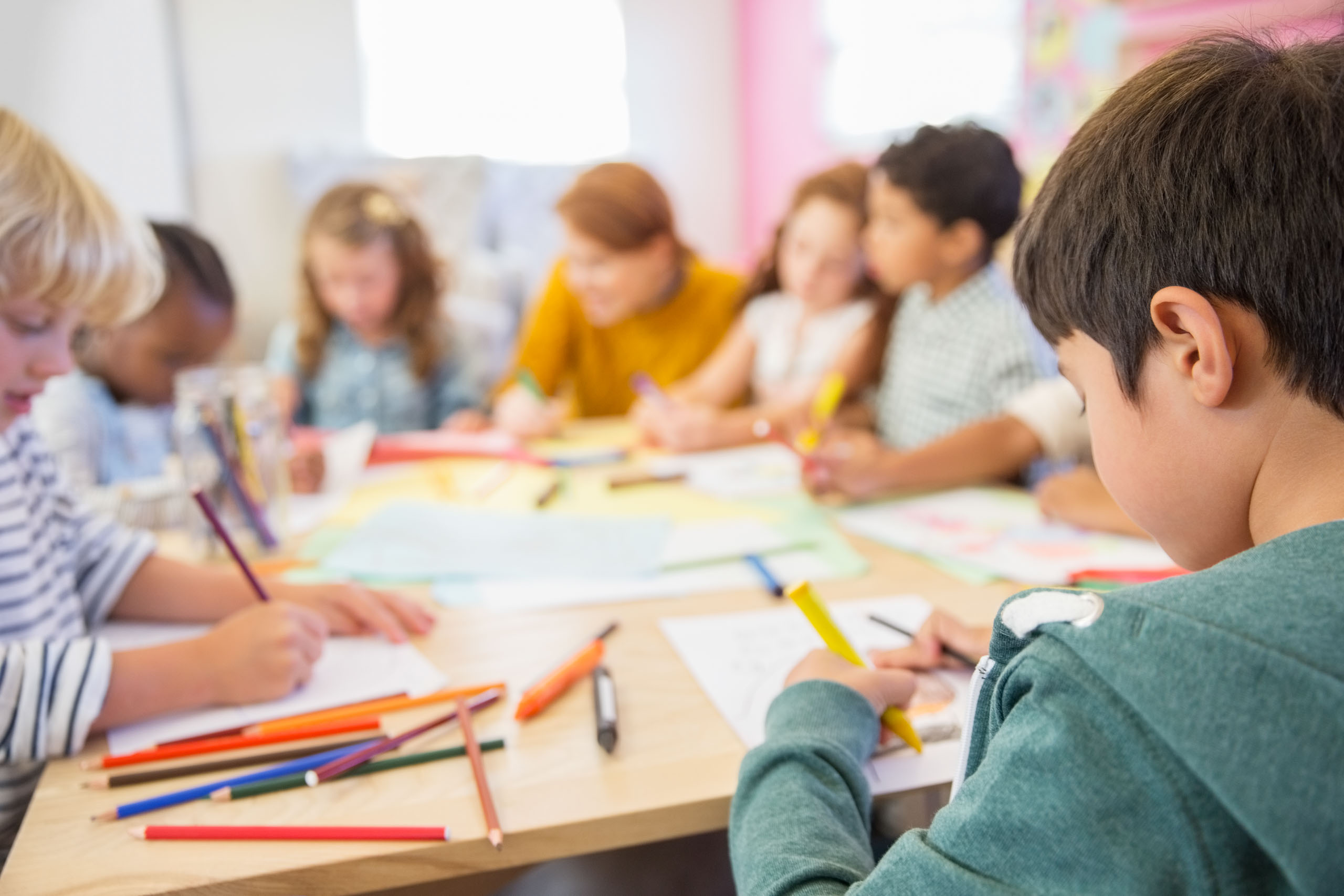 children coloring at a table.