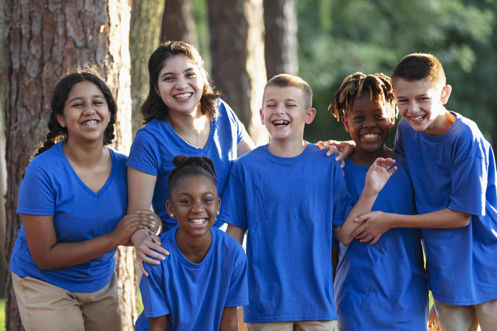 Photo of a group of children with their arms around each other and smiling